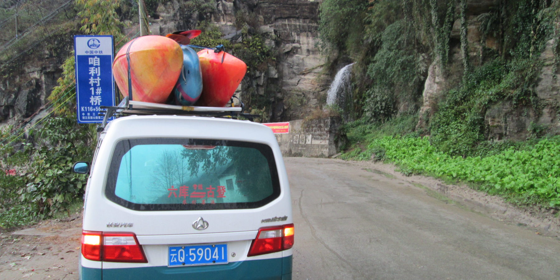 Van with Kayaks and waterfall driving up the Salween Drainage