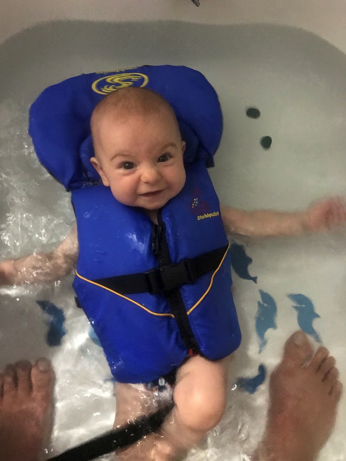 baby floating in infant life jackett PFD