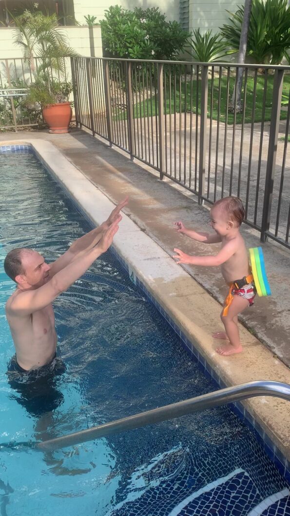 toddler jumping into pool with back float
