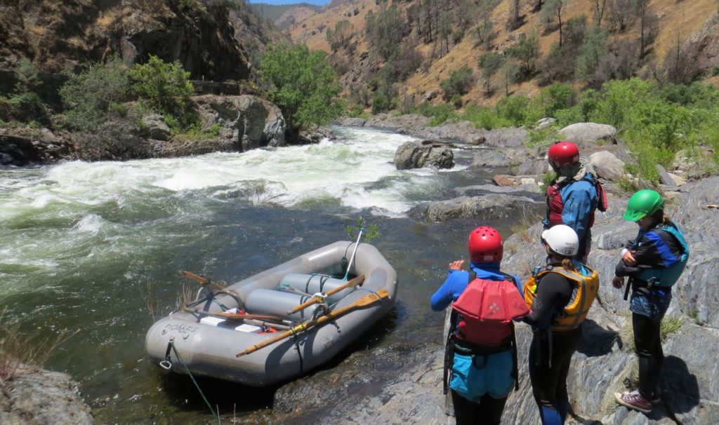 guides scouting rapids from shore