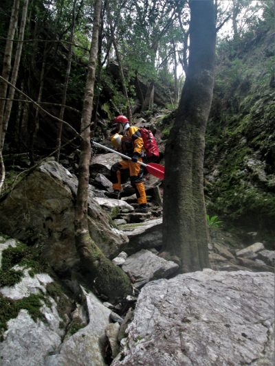 kayaker carrying gear on portage along the Franklin River